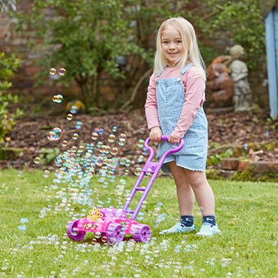 This is an image of a young girl playing with one of Sambro's toys, the bubble blower mower!